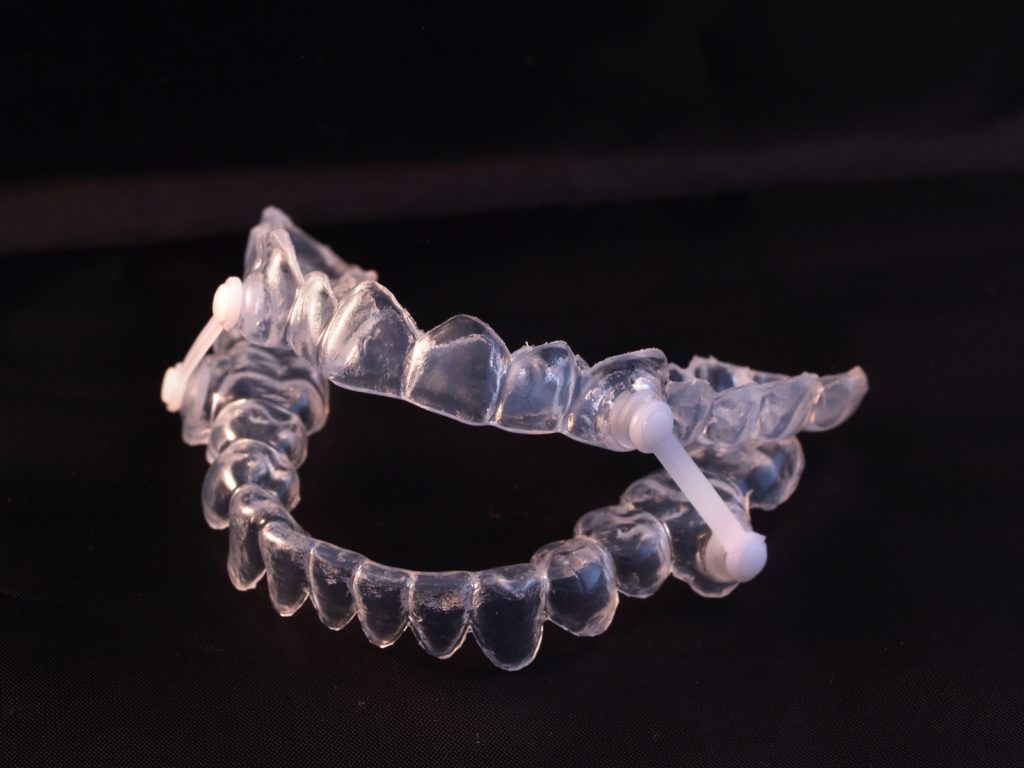 Sleep Apnea Dental Appliance shown in clear on black background